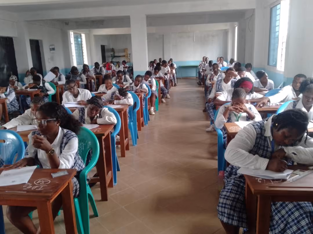 Une salle de cours de l'IFPPB : les apprenantes, toutes en tenue scolaire, travaillent à des tables individuelles.